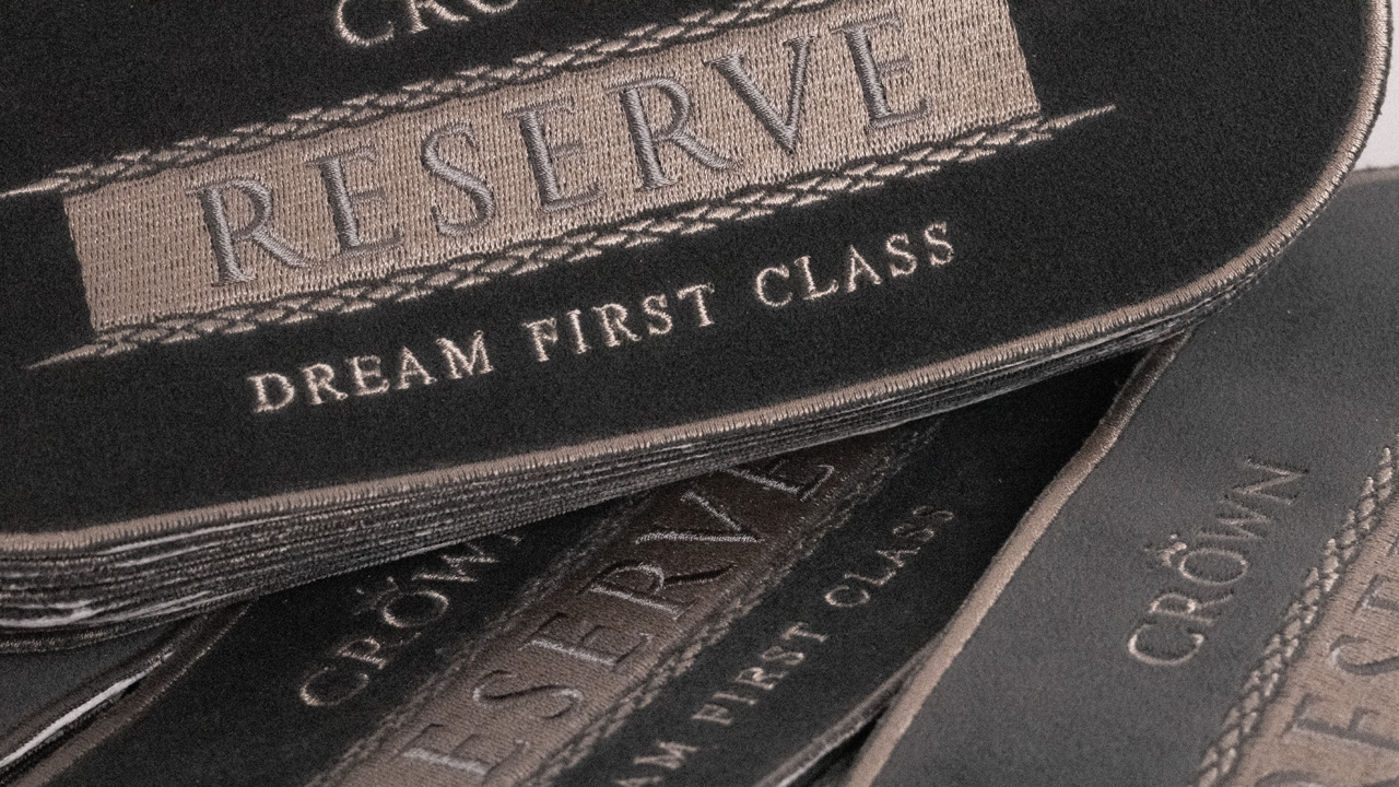 Close up of embroidered Crown Reserve bed badges.