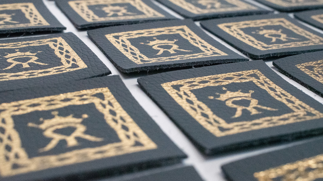 Close up of gold-foiled Crown Bed Handle Badges.
